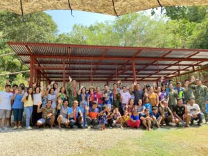 A group image where people smile and some wave their hands in front of a newly-built warehouse