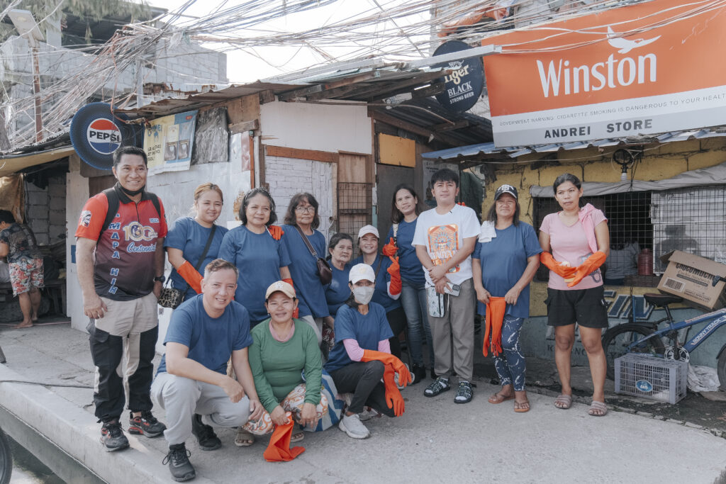 A group photo of men and women wearing orange gloves